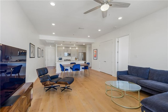 living area featuring recessed lighting, visible vents, light wood-style floors, and a ceiling fan