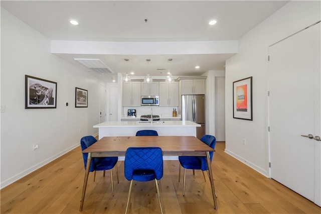 dining space with recessed lighting, baseboards, and light wood finished floors