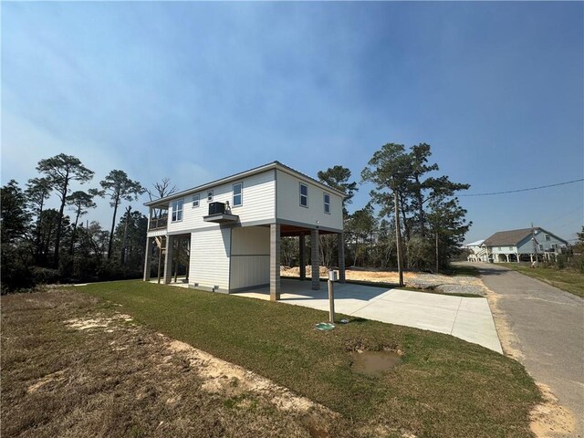 5019 Colorado St, Bay Saint Louis, MS 39520 - view of property exterior with a carport, concrete driveway, and a yard
