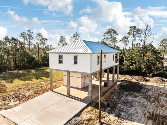 5019 Colorado St, Bay Saint Louis, MS 39520 - rear view of property with metal roof, a carport, concrete driveway, and a standing seam roof