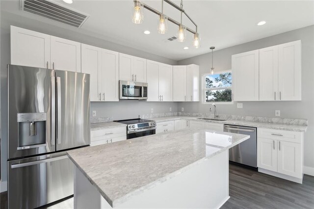 5019 Colorado St, Bay Saint Louis, MS 39520 - kitchen featuring visible vents, a sink, stainless steel appliances, white cabinets, and a center island