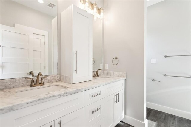 5019 Colorado St, Bay Saint Louis, MS 39520 - bathroom featuring double vanity, wood finished floors, visible vents, and a sink