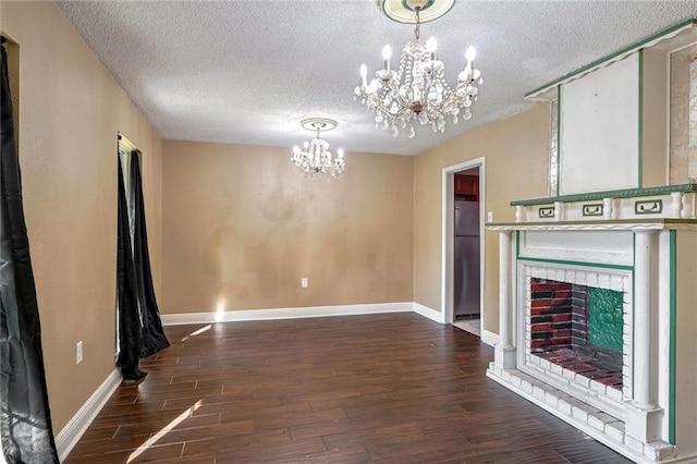 unfurnished living room featuring an inviting chandelier, a textured ceiling, and dark wood-type flooring