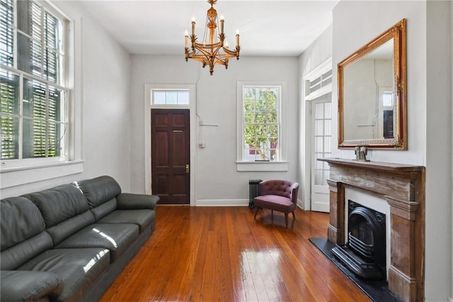 1135 Ursulines Ave, New Orleans, LA 70116 - living room featuring a notable chandelier, hardwood / wood-style flooring, and radiator