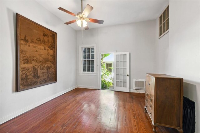 1135 Ursulines Ave, New Orleans, LA 70116 - empty room with dark wood-type flooring, ceiling fan, french doors, and a wall mounted AC