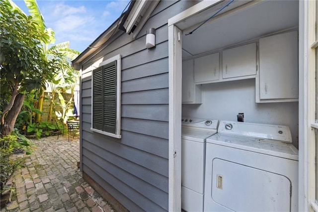 1135 Ursulines Ave, New Orleans, LA 70116 - clothes washing area with independent washer and dryer and cabinets
