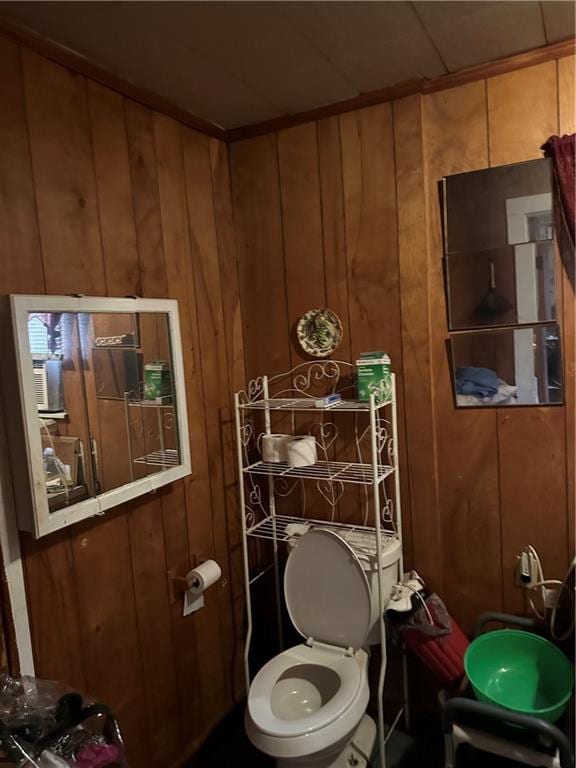 bathroom featuring toilet and wood walls