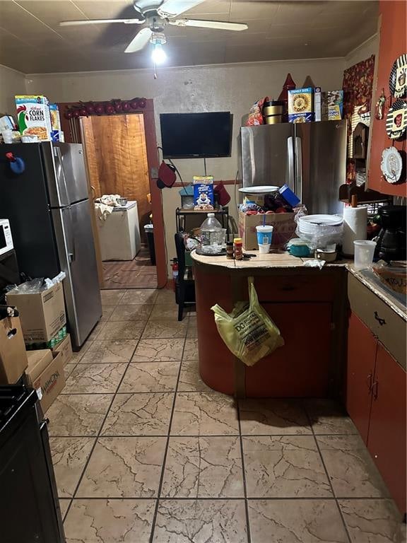 kitchen with ornamental molding, washer / clothes dryer, ceiling fan, and stainless steel refrigerator