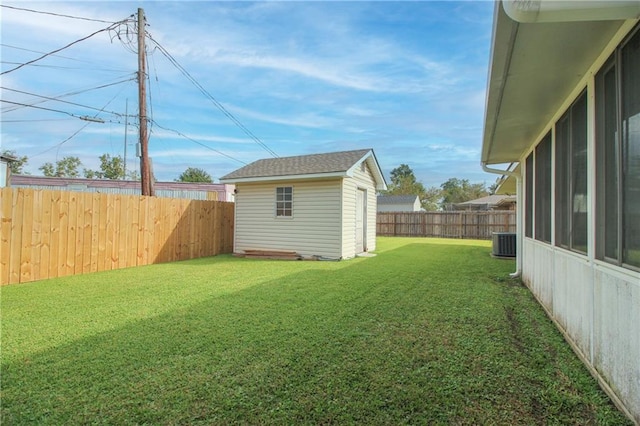 view of yard with central AC and a storage shed