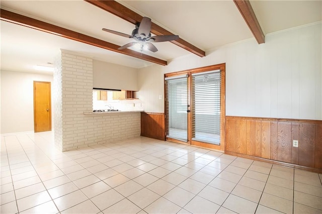 interior space with beam ceiling, ceiling fan, and wood walls