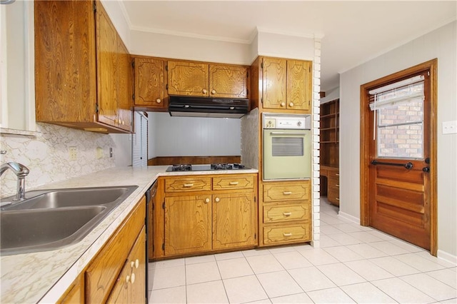 kitchen with gas stovetop, white oven, range hood, light tile patterned floors, and tasteful backsplash