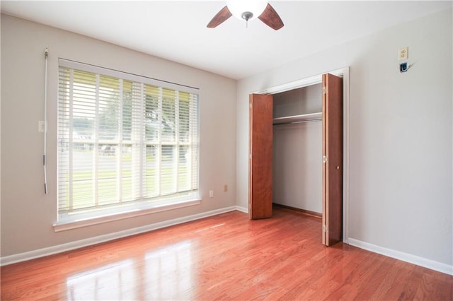 unfurnished bedroom with multiple windows, light wood-type flooring, and ceiling fan