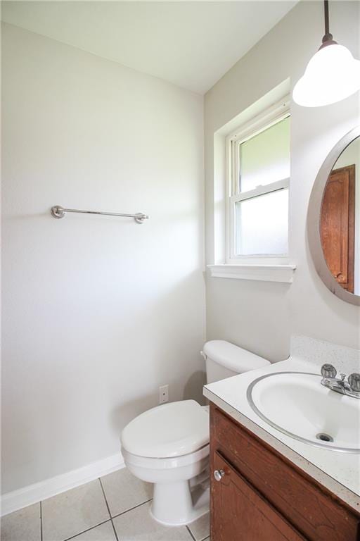 bathroom with toilet, vanity, and tile patterned floors