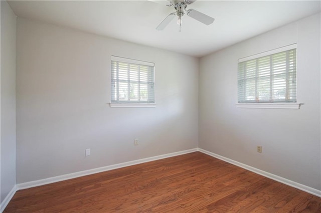 spare room with dark wood-type flooring and ceiling fan