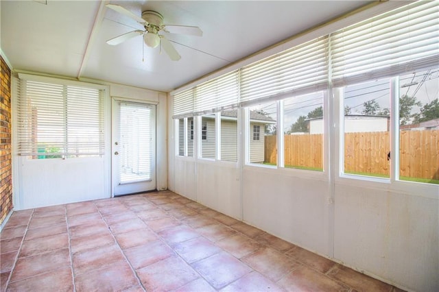 unfurnished sunroom with ceiling fan and plenty of natural light