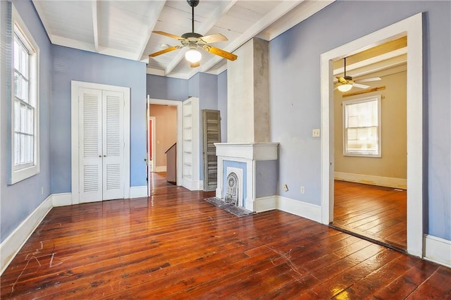 unfurnished living room featuring ceiling fan, beamed ceiling, and hardwood / wood-style floors