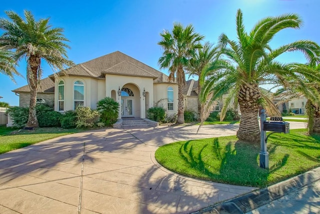 mediterranean / spanish house featuring a front lawn