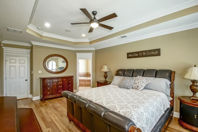 bedroom featuring ornamental molding, light hardwood / wood-style flooring, a tray ceiling, and ceiling fan