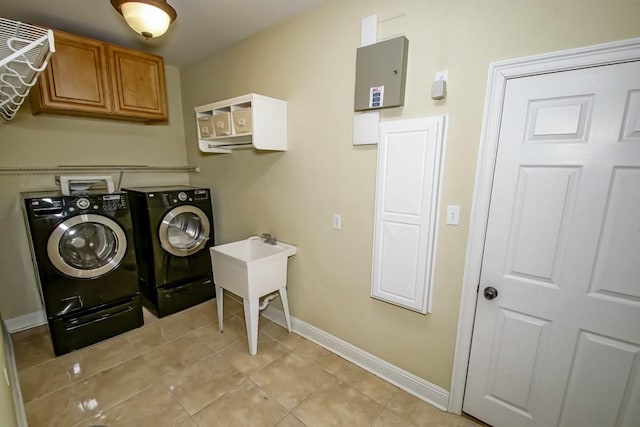 laundry room with cabinets, light tile patterned flooring, sink, and washer and clothes dryer