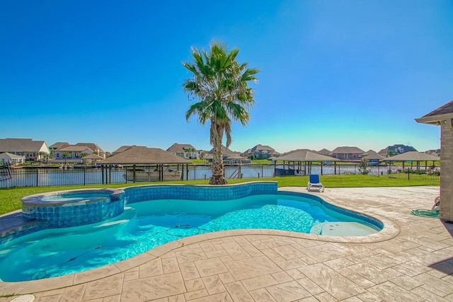 view of swimming pool featuring a patio, an in ground hot tub, a water view, and a lawn