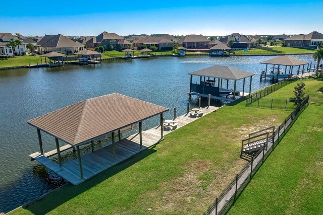 dock area with a water view and a yard