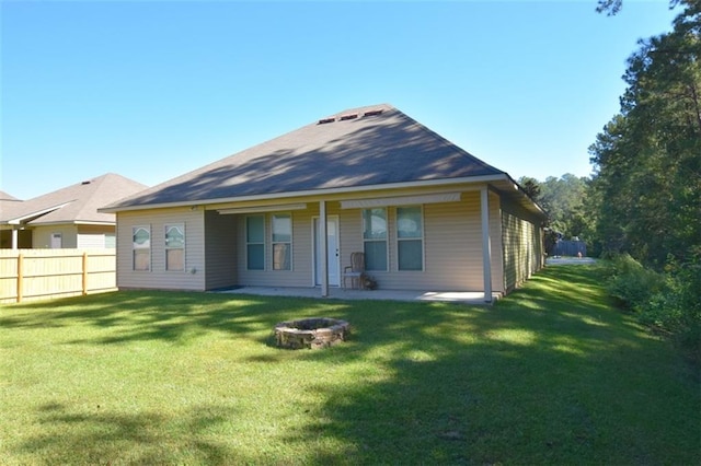 back of house featuring a yard and an outdoor fire pit