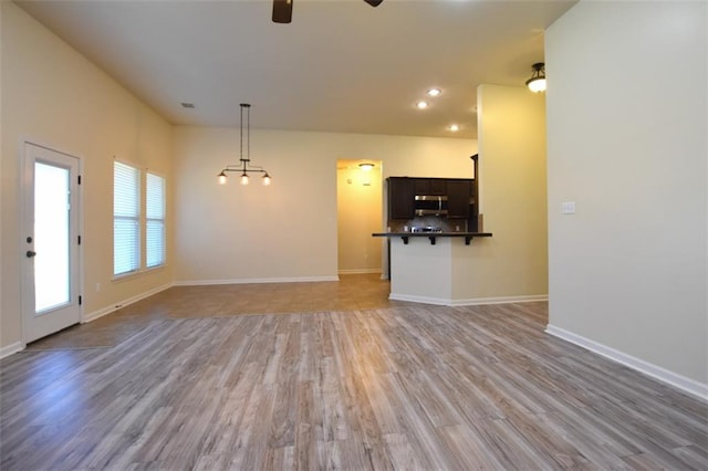 unfurnished living room featuring light hardwood / wood-style floors and ceiling fan