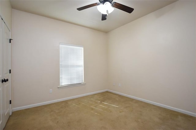 carpeted spare room featuring ceiling fan