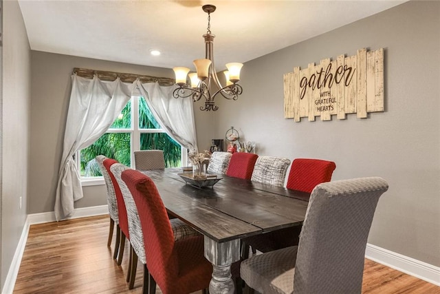 dining room with a notable chandelier and wood-type flooring