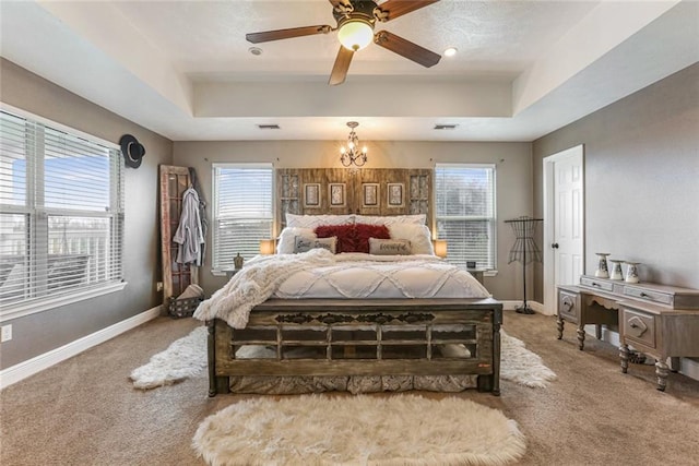 bedroom featuring carpet flooring, multiple windows, and ceiling fan with notable chandelier