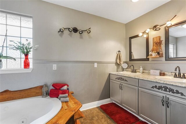 bathroom with vanity, a tub to relax in, and tile patterned flooring