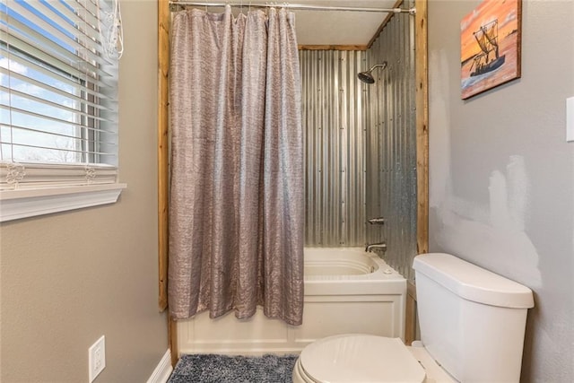 bathroom featuring shower / bath combo with shower curtain and toilet