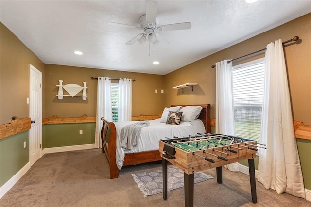 carpeted bedroom featuring multiple windows and ceiling fan