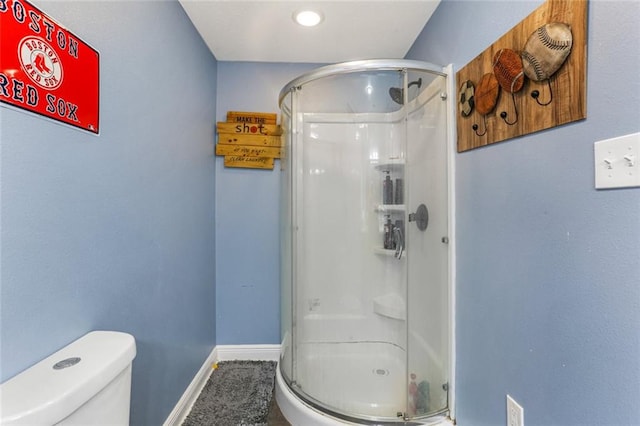 bathroom featuring toilet and an enclosed shower