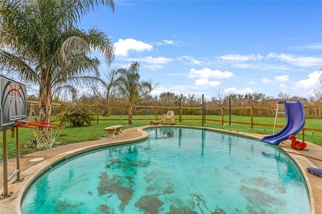 view of pool featuring a water slide and a lawn