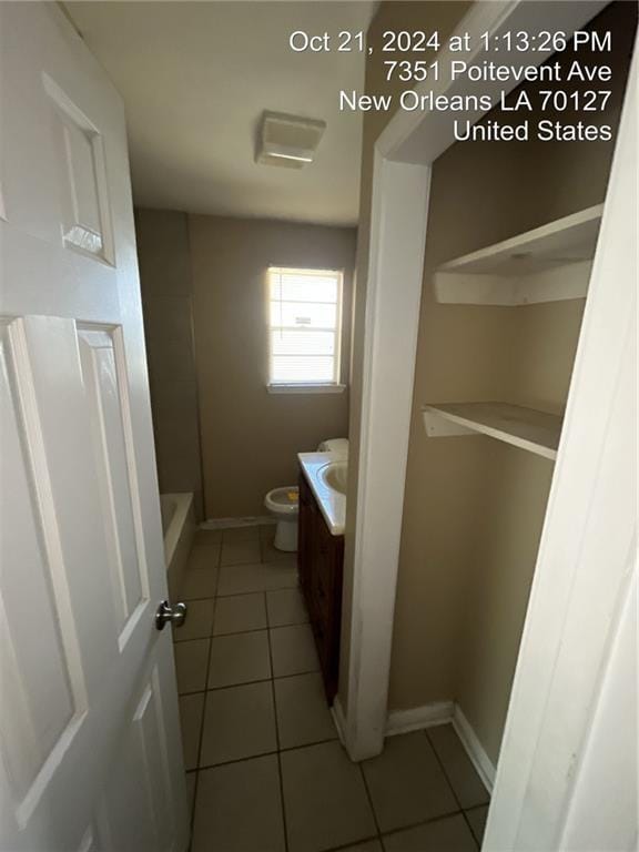 bathroom with walk in shower, vanity, toilet, and tile patterned flooring