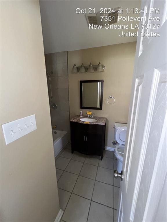 full bathroom featuring tiled shower / bath, vanity, toilet, and tile patterned floors