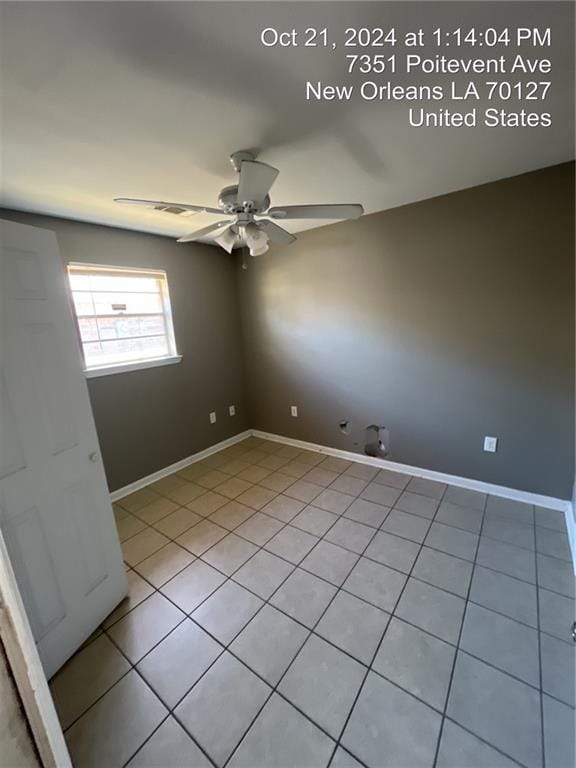 tiled empty room featuring ceiling fan