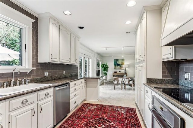 kitchen with a wealth of natural light, a sink, white cabinetry, and appliances with stainless steel finishes