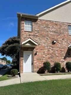 view of front of home with brick siding and a front lawn