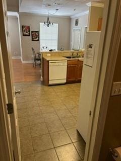 kitchen with pendant lighting, light countertops, ornamental molding, a sink, and dishwasher