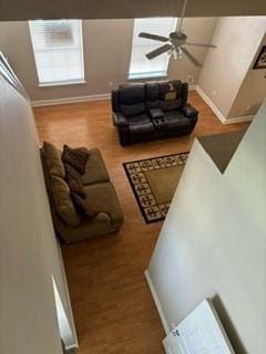 living area with ceiling fan, baseboards, and wood finished floors