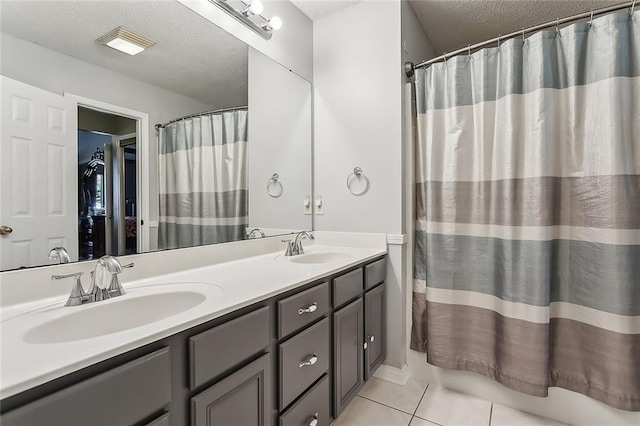 bathroom featuring vanity, curtained shower, a textured ceiling, and tile patterned floors