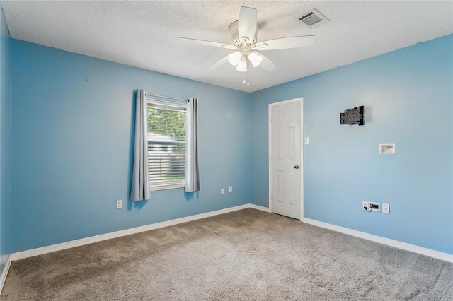 carpeted spare room featuring ceiling fan and a textured ceiling