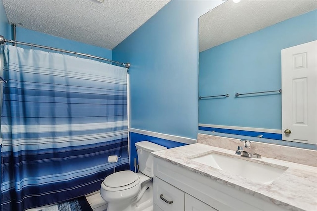 bathroom with vanity, toilet, a textured ceiling, and a shower with curtain