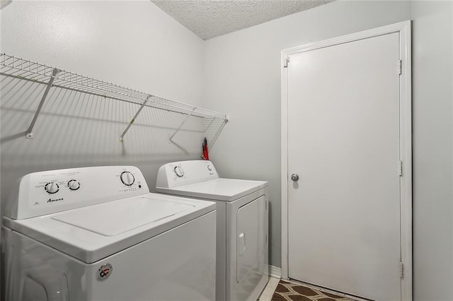 laundry room with washing machine and dryer and a textured ceiling