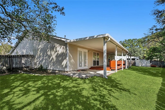 rear view of property with a patio area, french doors, and a lawn