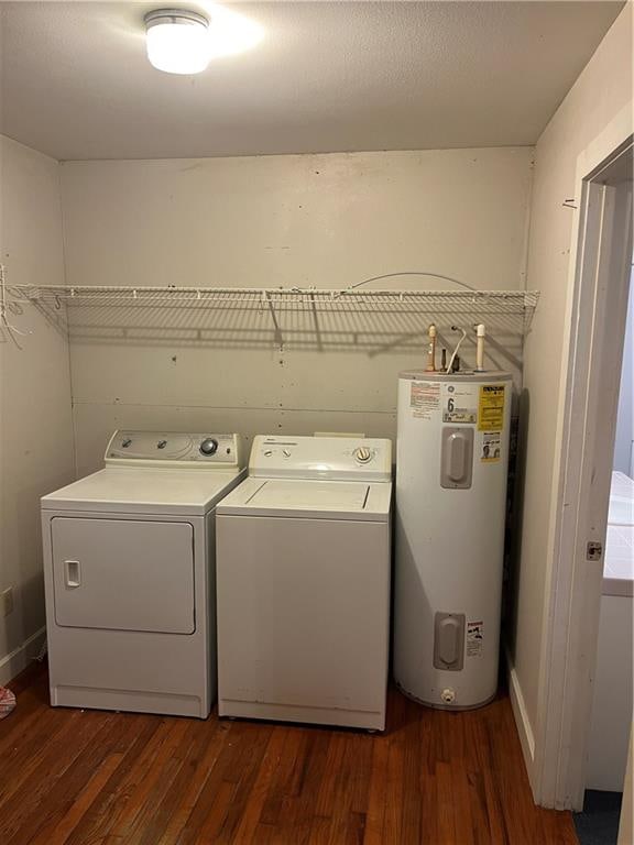 washroom with dark wood-type flooring, electric water heater, and washing machine and clothes dryer