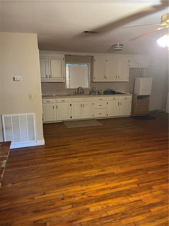 kitchen with sink, ceiling fan, dark hardwood / wood-style flooring, and white cabinets