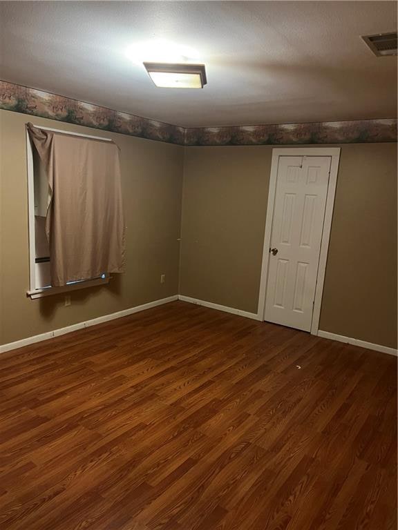 unfurnished room with dark hardwood / wood-style floors